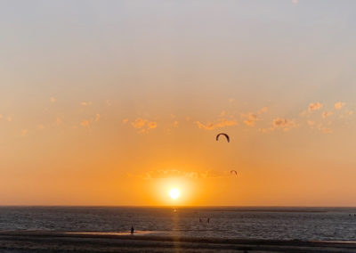 Kitesurfer am Strand von Baltrum bei Sonnenuntergang