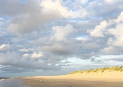 Sandstrand hell beleuchtet mit Wolken auf Baltrum