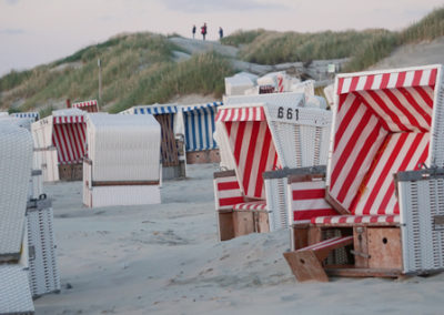 Blaue und rote Strandkörbe am Strand von Baltrum