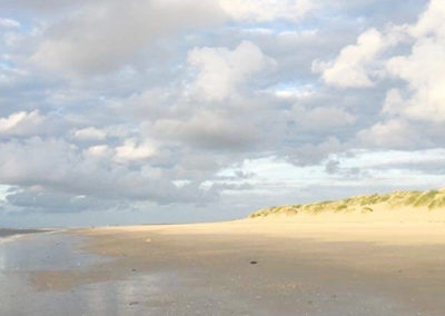 Schöner Sandstrand mit Wolken von der Sonne beleuchtet