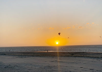 Mehrere Kitesurfer Abends auf dem Wasser